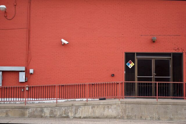 Security camera and rear entrance on a commercial building: Business Crime in Britain: Close to a Third of Firms Face Being Targeted This Year
