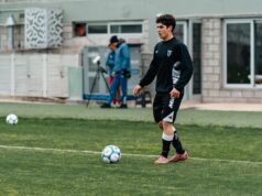 Club Football vs International Football: How the Two Seasons Interconnect A footballer in training walking towards a ball on the pitch