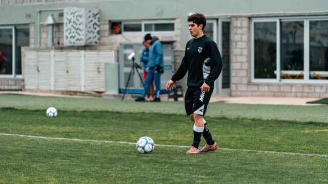 Club Football vs International Football: How the Two Seasons Interconnect A footballer in training walking towards a ball on the pitch