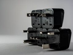 Electrical Safety at Work: What is Competence & Why It Matters Stack of black electrical plug adapters with different pin types on a grey surface