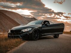 Why Replacing a Car Part Shouldn’t Mean Replacing the Car Black BMW coupe parked at the roadside with its door open at sunset