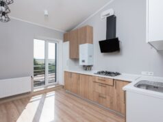 The Landlord Safety Checklist: What Actually Has to Be Tested, and How Often Empty rental flat kitchen with a wall-mounted gas boiler, gas hob and radiator