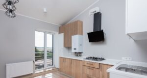 Empty rental flat kitchen with a wall-mounted gas boiler, gas hob and radiator