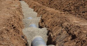 Drainage pipe laid on a gravel bed in an open trench