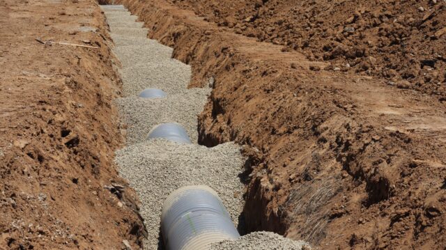 who-owns-the-drain-a-plain-guide-to-drain-responsibility-for-uk-homeow Drainage pipe laid on a gravel bed in an open trench